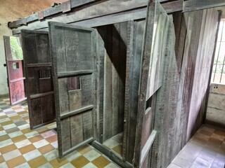 Phnom Penh, Cambodia - 25 June 2025. Wooden solitary cells at Tuol Sleng Genocide Museum reveal...