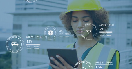 Reviewing engineer reading tablet on building site, with yellow safety helmet, reflective vest