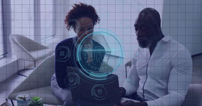 Two professionals in business clothes reviewing laptop in office lounge, with interface and plant