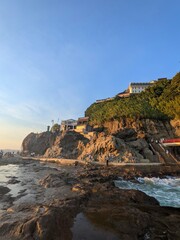Naklejka premium Seaside Cliffs with Traditional Buildings at Sunset in Japan