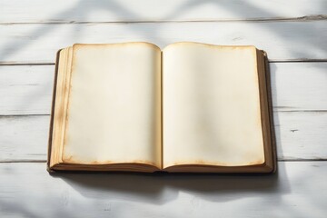 Open old blank book with yellowed pages on white wooden table under soft natural light