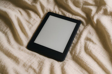 E-reader device placed on bed, cozy setup with neutral tones, great for marketing, design overlays, or editorial content.