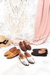 A variety of leather shoes arranged on a fabric background, perfect for leather industry catalog design.