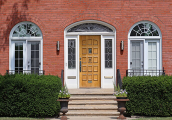 Wood grain front door of brick house