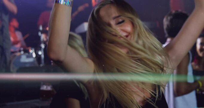Woman lifting glass mug and inviting dancing inside busy bar, joining live band energy