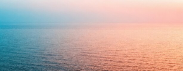 Fototapeta premium Calm ocean water reflecting a gradient of pastel colors from blue to pink during a serene sunset view