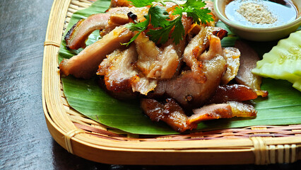 Grilled pork neck on a bamboo plate