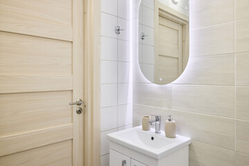 This is a Modern Bathroom featuring a Stylish Sink and an Illuminated Mirror for ambiance