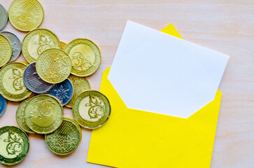 Coins and white notepad in an envelope with customizable space for text or ideas