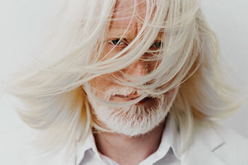 Portrait of an elderly man with long white hair and beard, captured with a soft focus on a light background, conveying a sense of wisdom and serenity, emotional and artistic expression