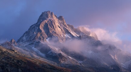 A majestic, snow-dusted mountain peak shrouded in mist under a soft, purple-hued sunrise sky, showcasing autumnal colors in the foreground