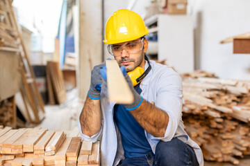 young male carpenter worker hold wooden plank at the carpentry workshop

