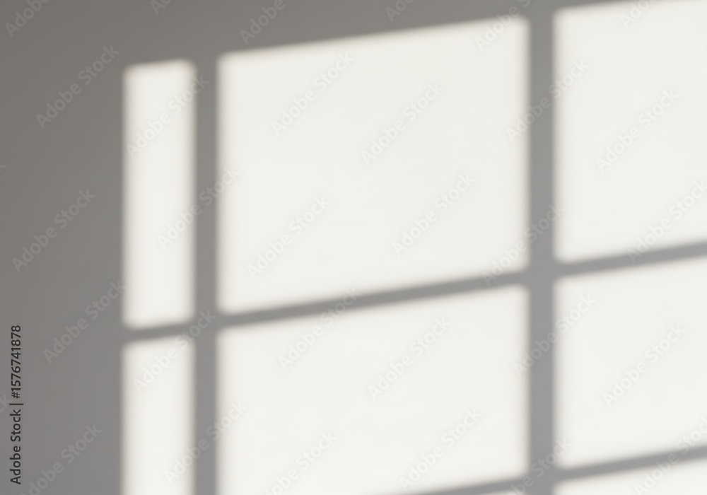 Poster shadows of a window frame cast geometric patterns on a white wall, creating an abstract composition.