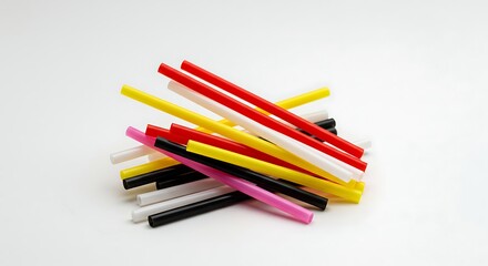 Fototapeta premium Colorful plastic straws scattered on a white surface in a close-up shot
