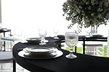 table set in ballroom, elegant wedding reception table with candlesticks, luxury dinner arrangement with floral centerpiece, formal dining table with clear chairs and silver candelabras
