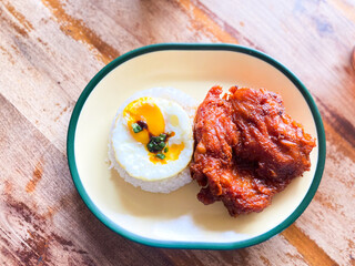 Delicious Fried Chicken with Rice and Sunny-Side Up Egg A Culinary Delight on a Rustic Wooden Table