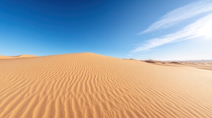 A vast desert landscape showcasing rolling dunes and a clear blue sky, perfect for travel and nature enthusiasts.