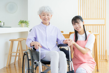 リビングで介護をする若い女性介護士