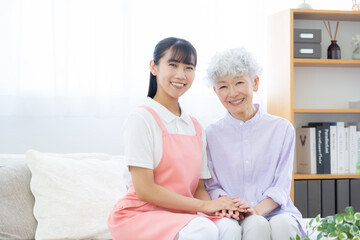 リビングで介護をする若い女性介護士