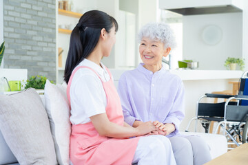 リビングで介護をする若い女性介護士