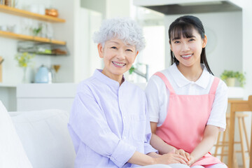 リビングで介護をする若い女性介護士