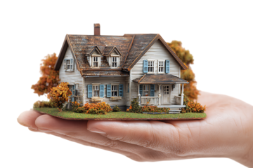 Hand holding a miniature house model.