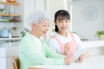 リビングで介護をする若い女性介護士