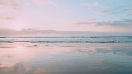 Fototapeta premium Soft pastel sunset painting the sky over a calm ocean beach, with gentle waves lapping the shore. The sky blends hues of pink, blue, and purple, while the water mirrors the serene colors, 