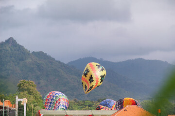 Tulungagung, Indonesia July 12, 2025: Colorful traditional hot air balloons rising during a...
