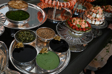 haute cuisine,japanese cuisine side dishes and condiments, metal bowls with gold details, wasabi, soy sauce, sesame seeds and seaweed, wakame, sunomonu
