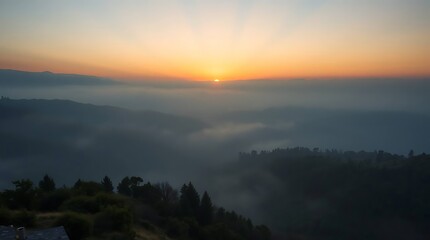 Sunrise above misty hills and forest