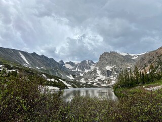 Panoramic view of snowy mountains of hike in Lake Isabelle in Colorado with storm clouds
