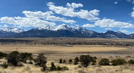 Panoramic view of snowy mountains in Colorado with farm field 
