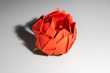 red origami rose bloom on gray background