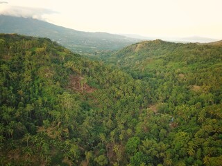 Beautiful sunrise over the mountains with a backdrop of tropical forest and clear sky.