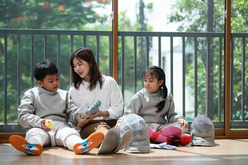 The fencers' families rest on the floor as they wait for the next round of the competition. Mother,...