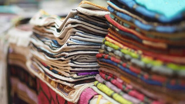 Colorful textiles stacked in a vibrant market bazaar