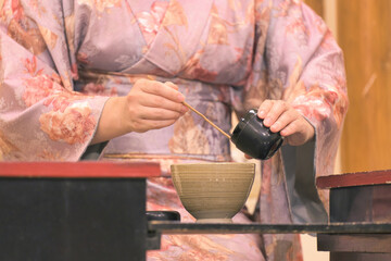 Traditional Japanese Tea Ceremony Performance: A Woman in Kimono Carefully Preparing Matcha Tea