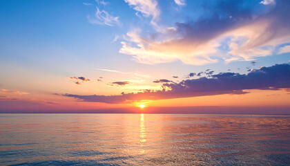 Fototapeta premium Serene Sunset Seascape: A breathtaking sunset paints the sky with vibrant hues of orange, pink, and purple, as the sun dips below the horizon, casting a warm glow on the calm ocean waters. 
