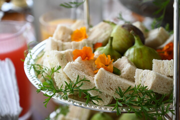bread with cheese and herbs, assorted tea sandwiches served on elegant tiered tray, gourmet finger...