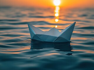 A paper boat floating on rippled ocean water during a vibrant sunset. Symbolizes journeys, hope, and new beginnings for creative projects.