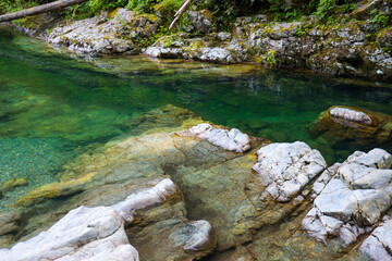 river with blue crystalline waters with rocks in the background