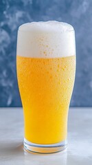 Refreshing Glass of Beer with Foam Against a Textured Background