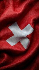 Close Up of a Waving Swiss Flag Made of Rich Red Fabric Featuring a White Cross