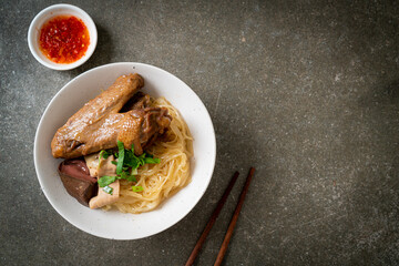 dried noodles with braised duck in white bowl