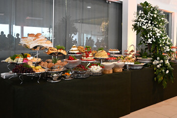 buffet, hotel buffet, elegant buffet table setup for special events, gourmet catering display with floral decoration, large self-service food station in banquet hall

