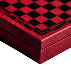 A close up of a red box with a checkered pattern on top against a black background surface view