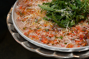 carpaccio , thin beef carpaccio with arugula and parmesan, gourmet meat appetizer with vinaigrette topping, elegant carpaccio platter served cold for events

