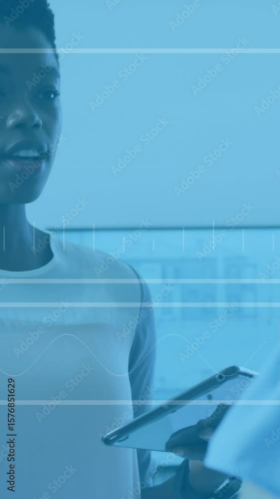 Poster animation of data processing over two diverse women discussing over a digital tablet at office