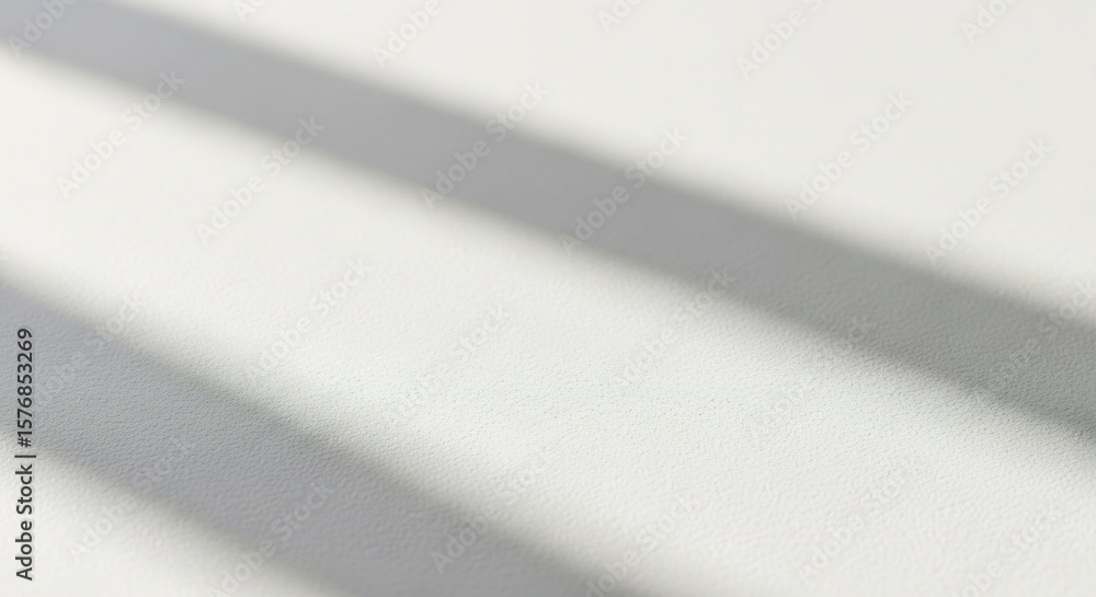 Poster diagonal shadows cast across a plain white surface, creating minimalist abstract shapes.